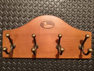 Perchero de madera con ganchos dorados de metal