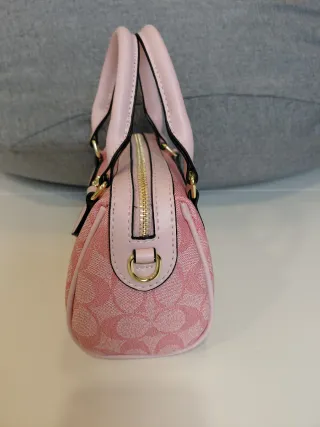 Bolso Coach rosa con charm de cerezas