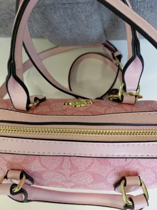 Bolso Coach rosa con charm de cerezas