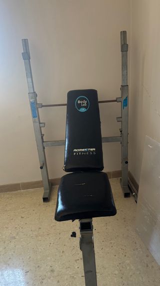 Banca de gimnasio con barra y discos