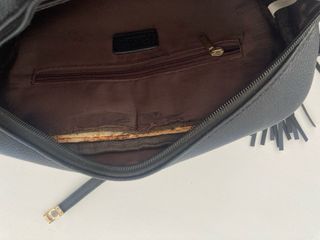 Bolso negro con flecos y detalle dorado