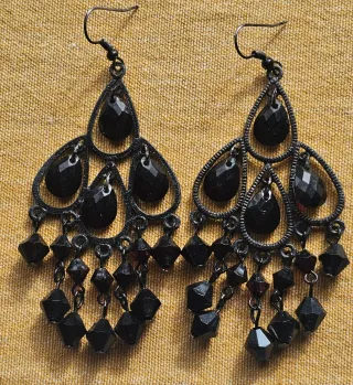 Pendientes largos con pedrería negra.