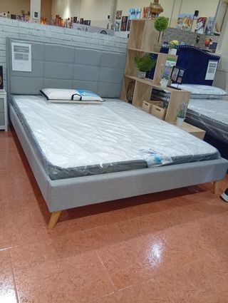 Cama tapizada gris con cabecero
