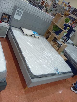 Cama tapizada gris con cabecero