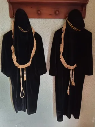 Túnicas negras con detalles dorados hechas a mano.