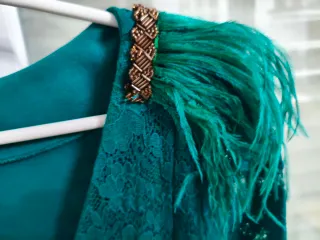 Vestido verde con plumas y pedrería