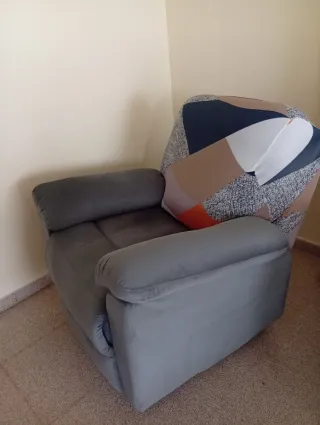 Sillón reclinable gris con funda multicolor