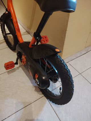 Bici infantil naranja con ruedines