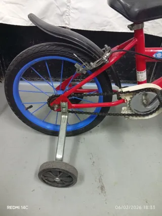 Bicicleta infantil roja con ruedines