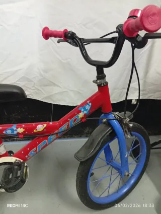 Bicicleta infantil roja con ruedines