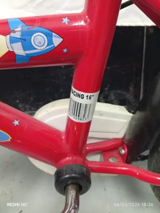 Bicicleta infantil roja con ruedines