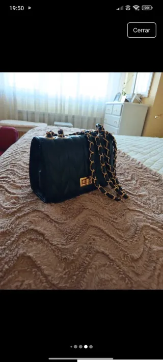Bolso de mano negro con cadena dorada