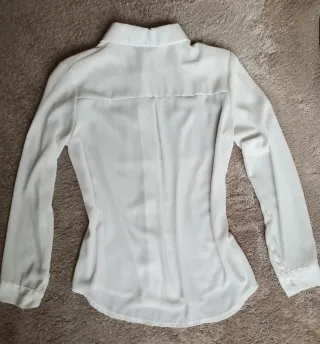 Camisa blanca fluida con flecos negros y tachuelas