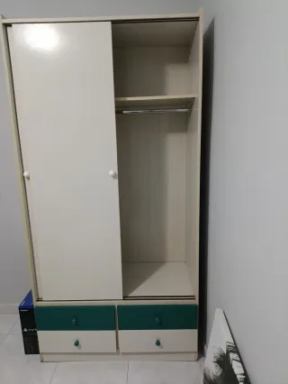 Armario blanco y verde con cajones.