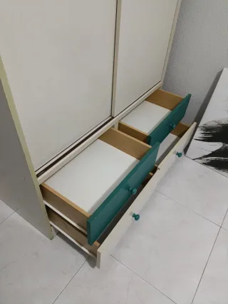 Armario blanco y verde con cajones.