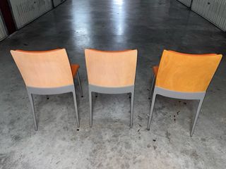 Juego de 3 sillas de oficina naranjas.