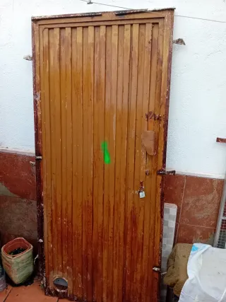 Puerta exterior metálica con cerradura y marco
