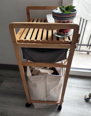 Mueble organizador con cesto ropa sucia y ruedas.