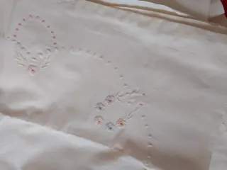 Sábana blanca bordada con iniciales y flores