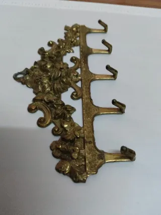 Perchero de bronce antiguo con adornos florales