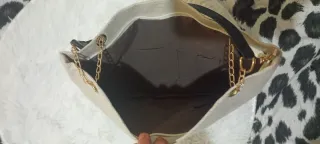 Bolso de mano beige y negro con adorno