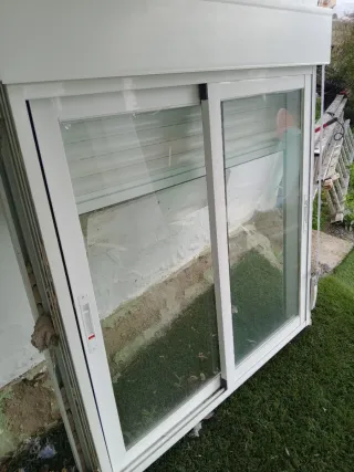 Ventana corredera blanca con persiana