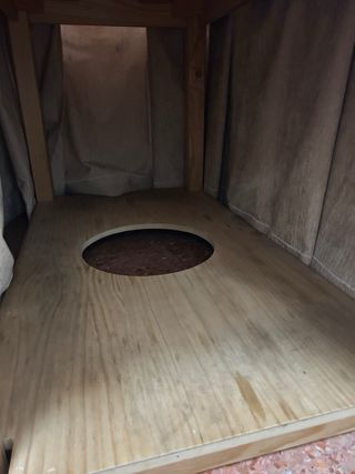 Mesa camilla rectangular de madera y paño beige.