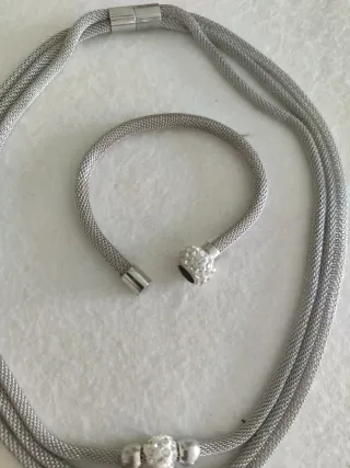 Collar triple y pulsera plateados con cierre imán.