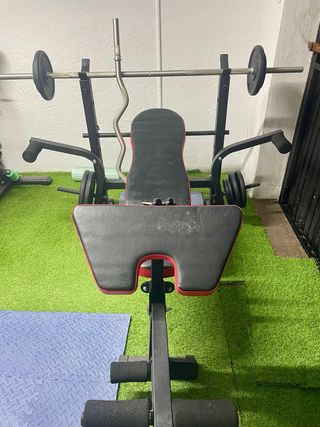 Banco de gimnasio con pesas y barras
