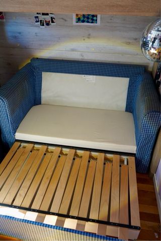 Sofá cama azul pull out con laminado madera. Ikea.