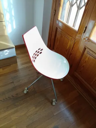 Silla de despacho blanca con detalles naranjas.