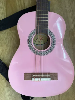 Guitarra acústica rosa con correa