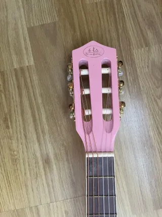 Guitarra acústica rosa con correa