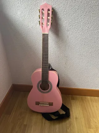 Guitarra acústica rosa con correa