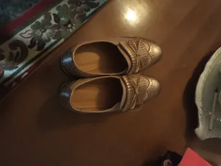 Zapatos dorados con flecos y lazo