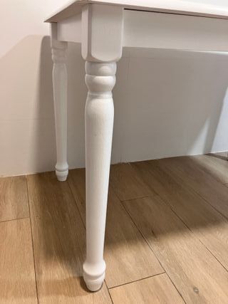 Mesa blanca con 2 sillas y 2 taburetes.