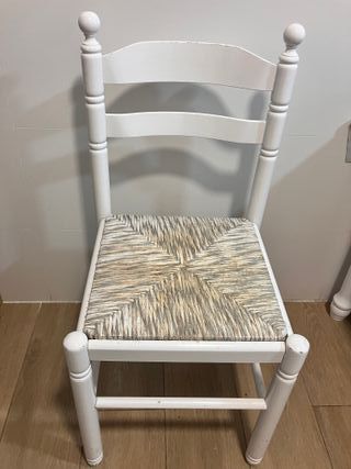 Mesa blanca con 2 sillas y 2 taburetes.