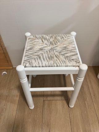 Mesa blanca con 2 sillas y 2 taburetes.