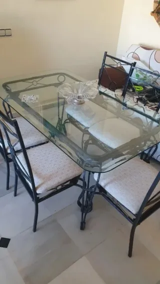 Mesa y sillas de comedor de metal y cristal.
