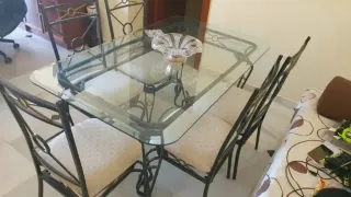 Mesa y sillas de comedor de metal y cristal.
