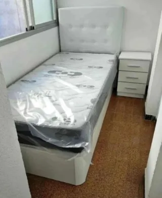 Cama individual blanca con cabecero