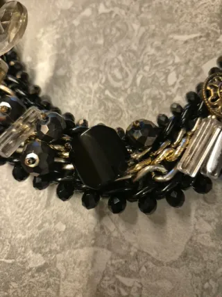 Collar joya negro y dorado con flores