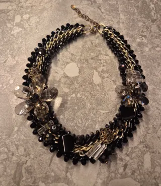 Collar joya negro y dorado con flores