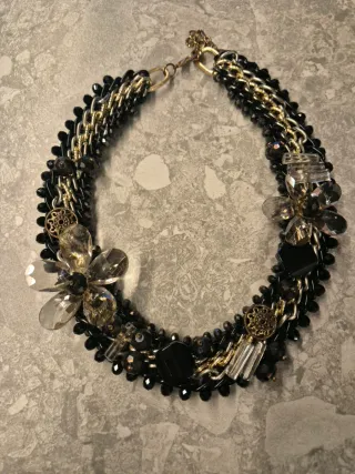 Collar joya negro y dorado con flores
