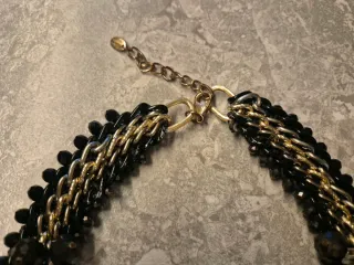 Collar joya negro y dorado con flores