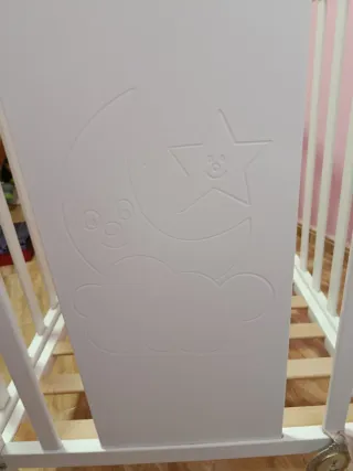 Cuna de bebé blanca con dibujos en relieve