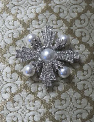 Broche plateado con perlas y pedrería