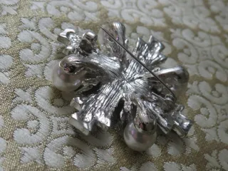 Broche plateado con perlas y pedrería