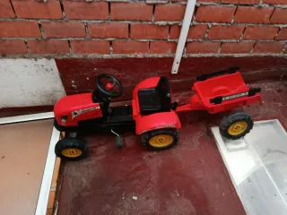 Tractor de pedales rojo con remolque