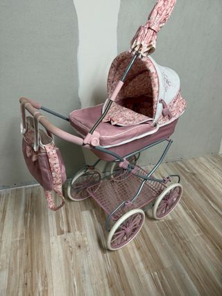Cochecito de muñecas rosa con sombrilla